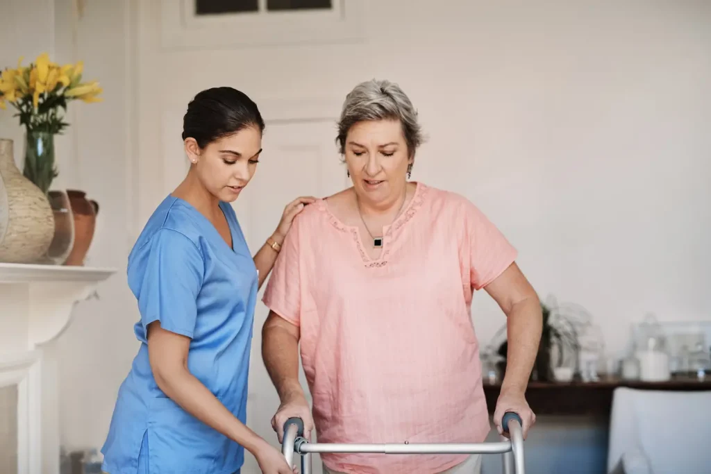 female nurse assisting participant to walk with a walking frame